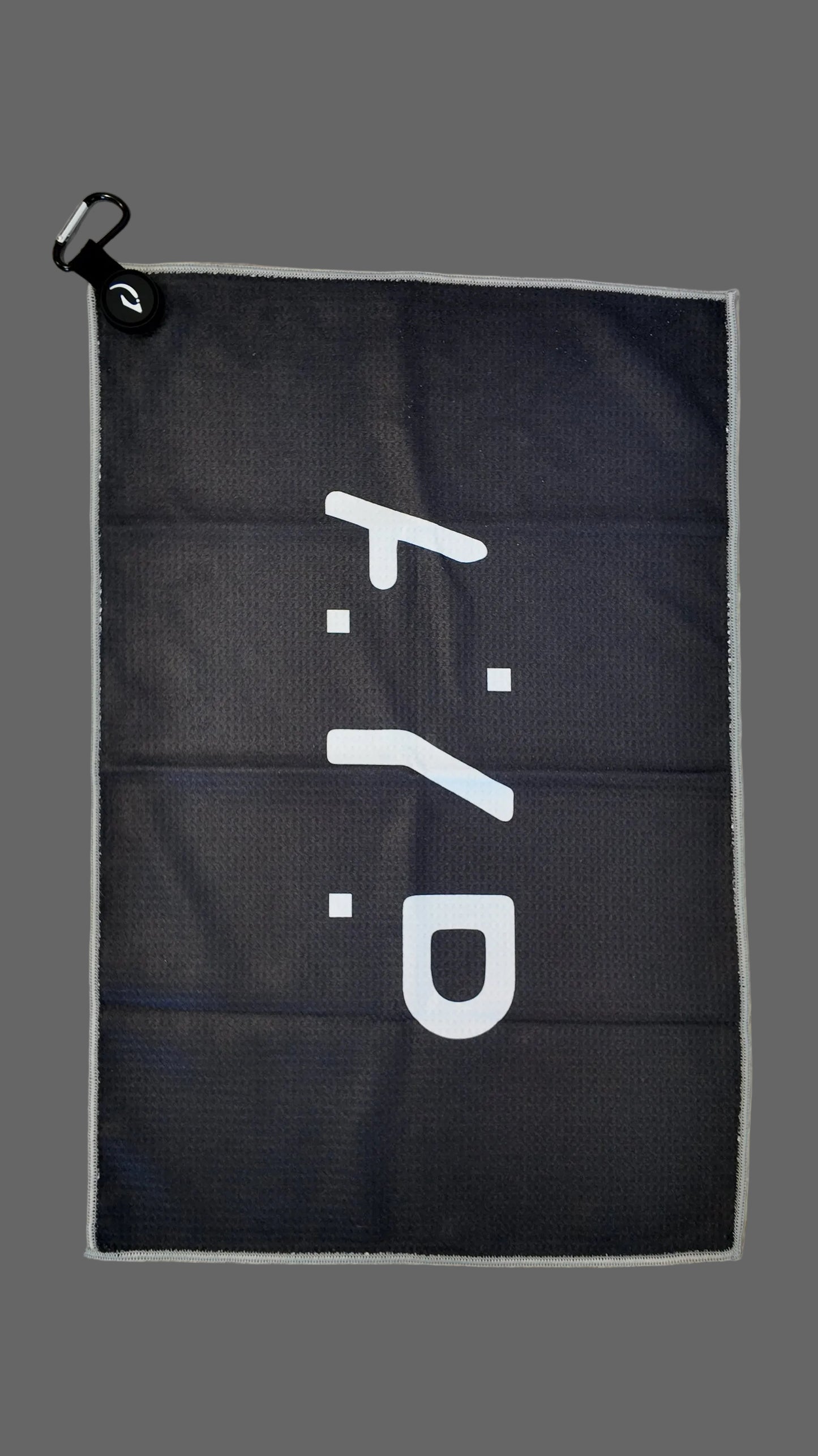 Black towel with white logo on a gray background